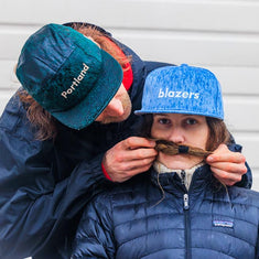 cute couple in the rain wearing blazers new era caps