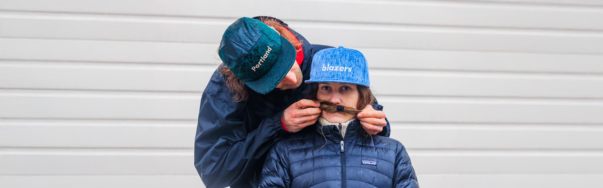 cute couple in the rain wearing blazers new era caps