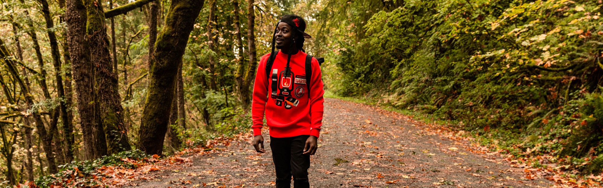 guy wandering in the woods in a red blazers sweatshirt