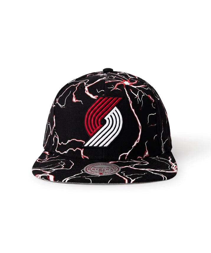 A black flat-brim snapback cap featuring a red and white Portland Trail Blazers logo on the front, decorated with a red and white lightning-bolt pattern across the crown and brim.