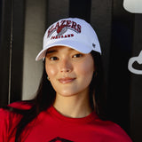 Person wearing a Portland Trail Blazers cap and red shirt in front of a black background with cloud designs.