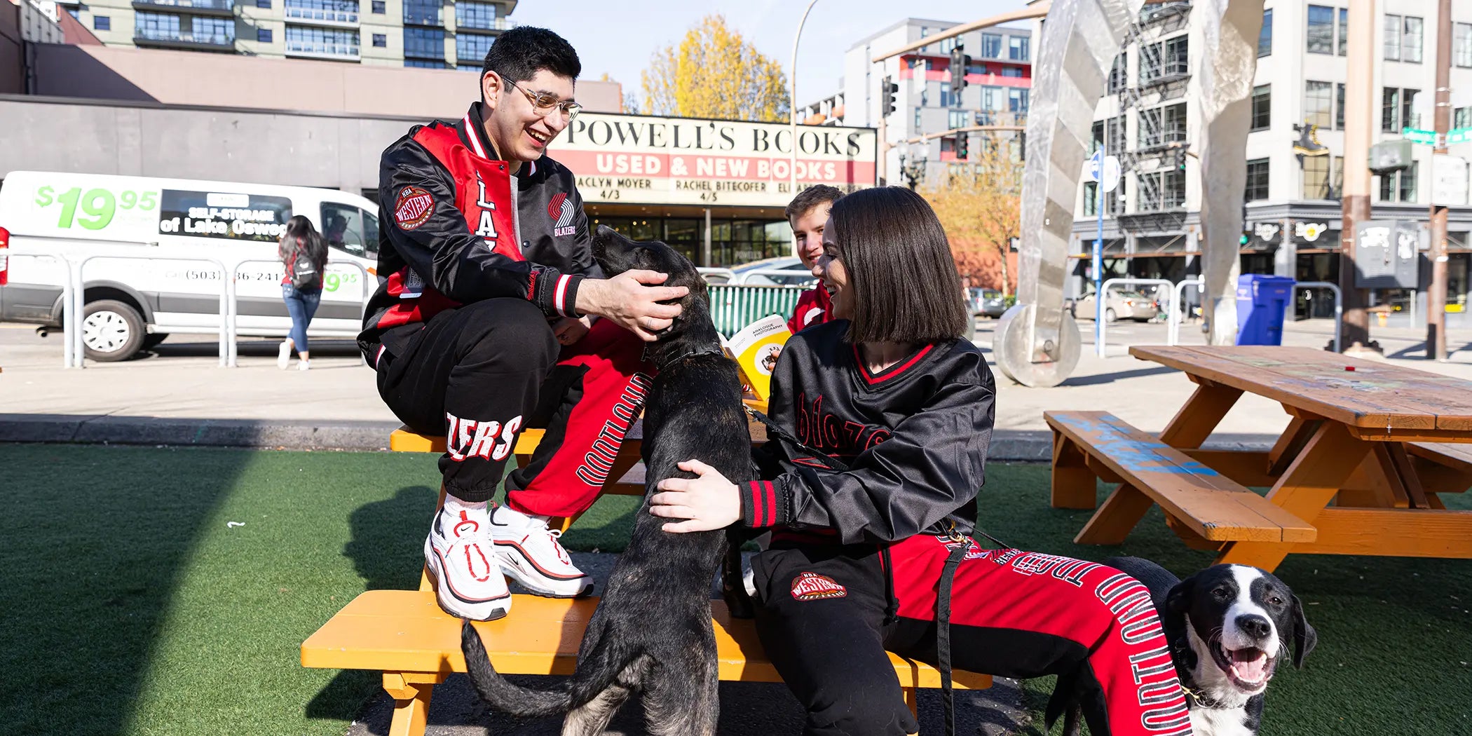 People sitting at a picnic table in front of Powells wearing new Blazers gear.