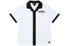 A white short-sleeve button-up shirt with a black collar, black sleeve cuffs, and red buttons down the front placket. The left chest features 'Portland  PDX' text, and a small black logo patch is visible on the bottom right hem.